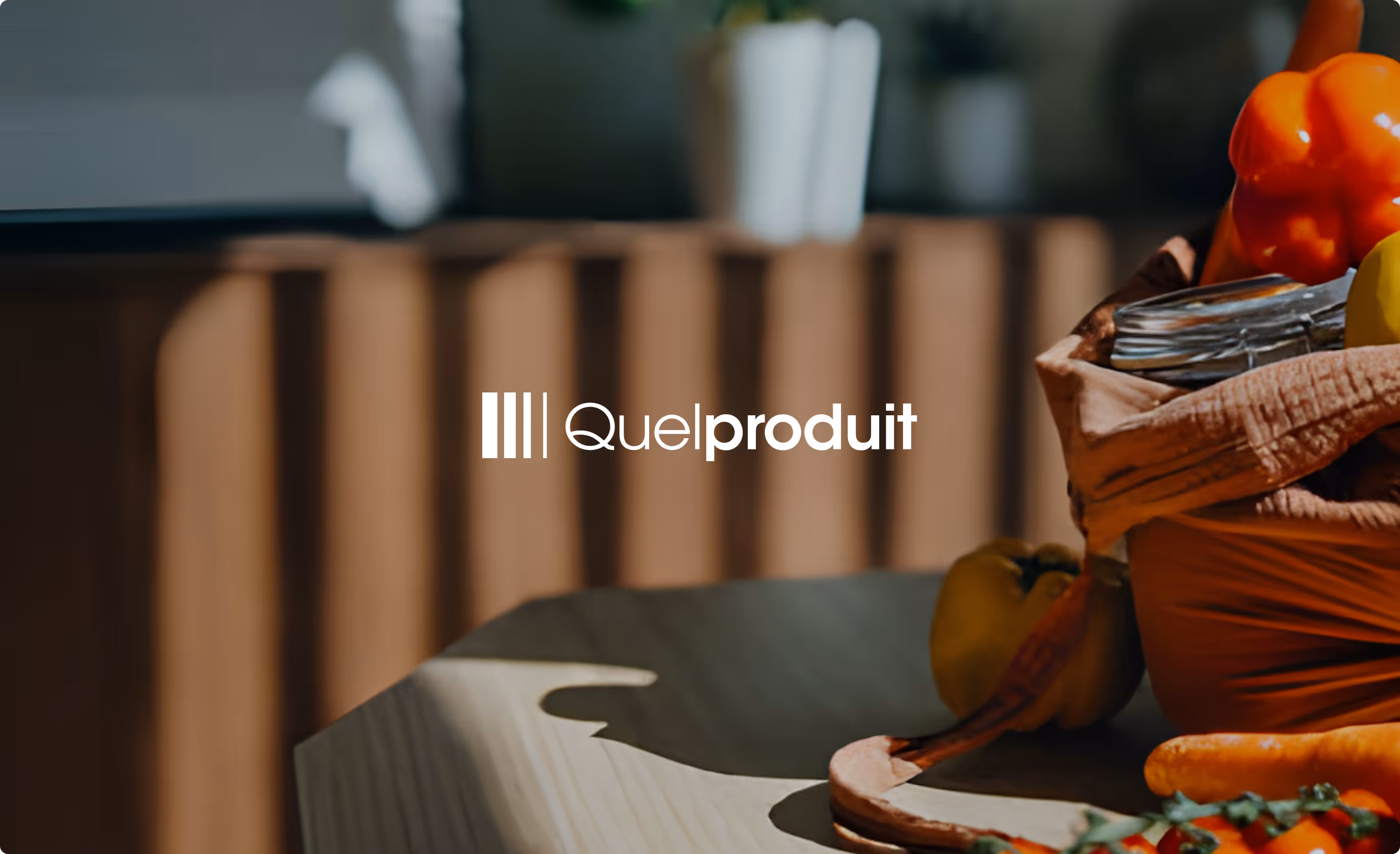 Logo Quelproduit blanc sur fond flou avec un panier contenant des légumes colorés comme poivron rouge, poivron jaune et carottes.
