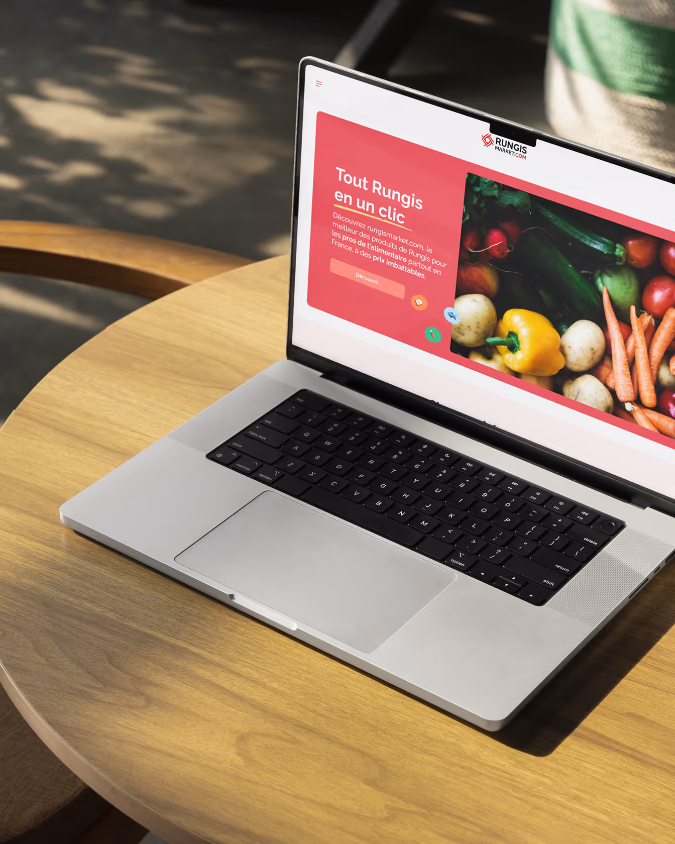 Ordinateur portable sur une table en bois affichant la page d’accueil du site Rungis Market avec légumes frais en photo.
