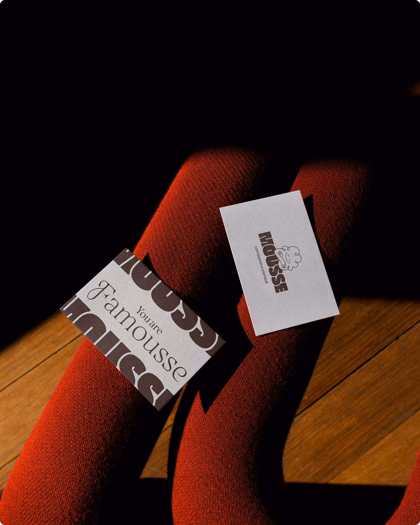 Cartes de visite Mousse posées sur un tissu rouge, avec les inscriptions « You are famousse » et « coffeeshop & coiffeur ».