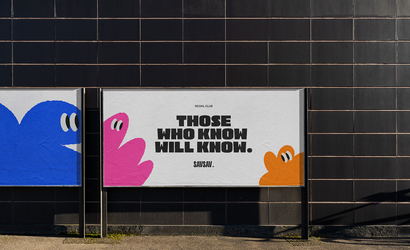 Une affiche publicitaire extérieure SavSav affiche le slogan « Those who know will know » avec des personnages colorés bleu, rose et orange.