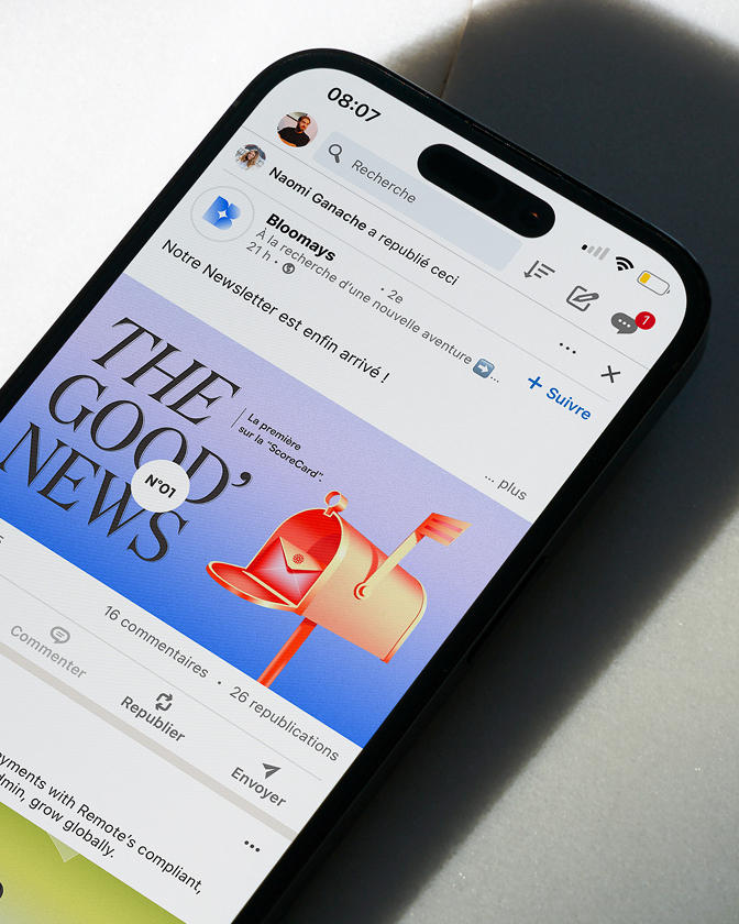 Smartphone affichant une page LinkedIn avec visuel coloré et texte The Good News.
