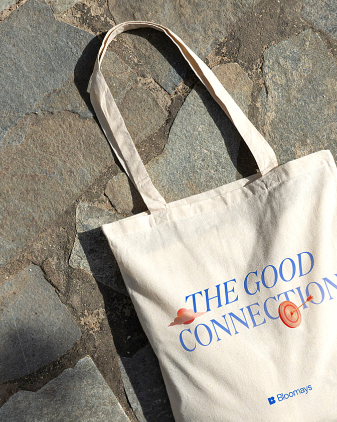 Sac en toile avec inscription The Good Connection posé sur un sol en pierre.