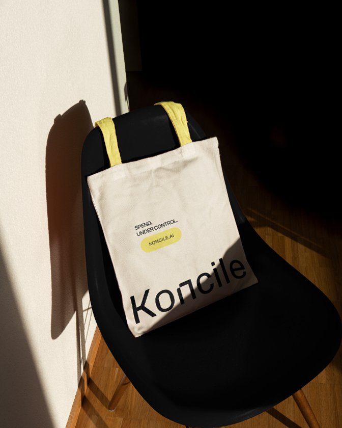 Sac en toile blanche avec logo Koncile posé sur une chaise noire.