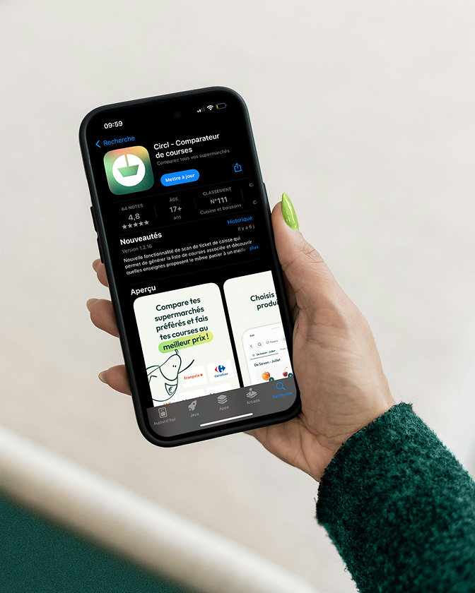 Main tenant un smartphone affichant la page de téléchargement d’une application sur l’App Store.