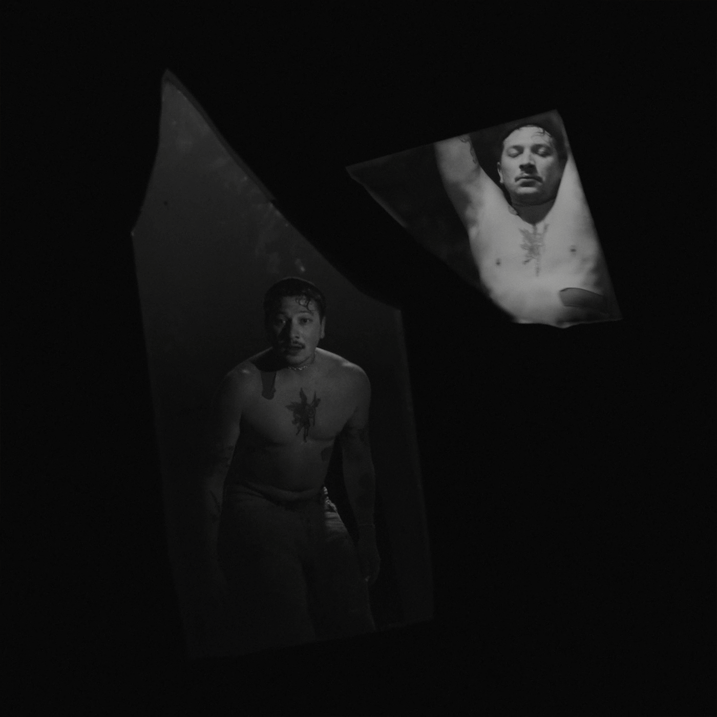 two broken mirrors hanging in the empty space with a man reflecting in both of them