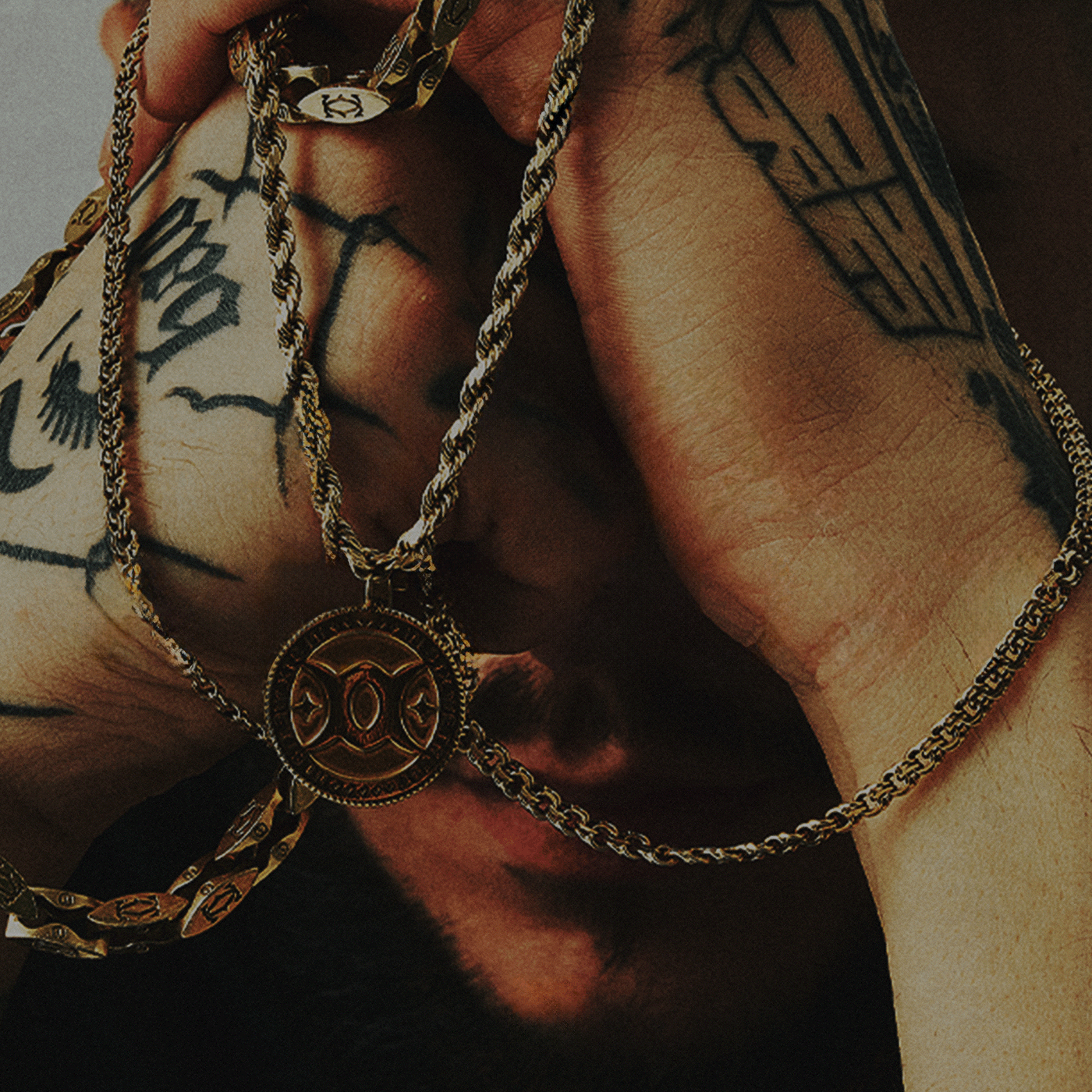 men holding gold chain with logo engraved