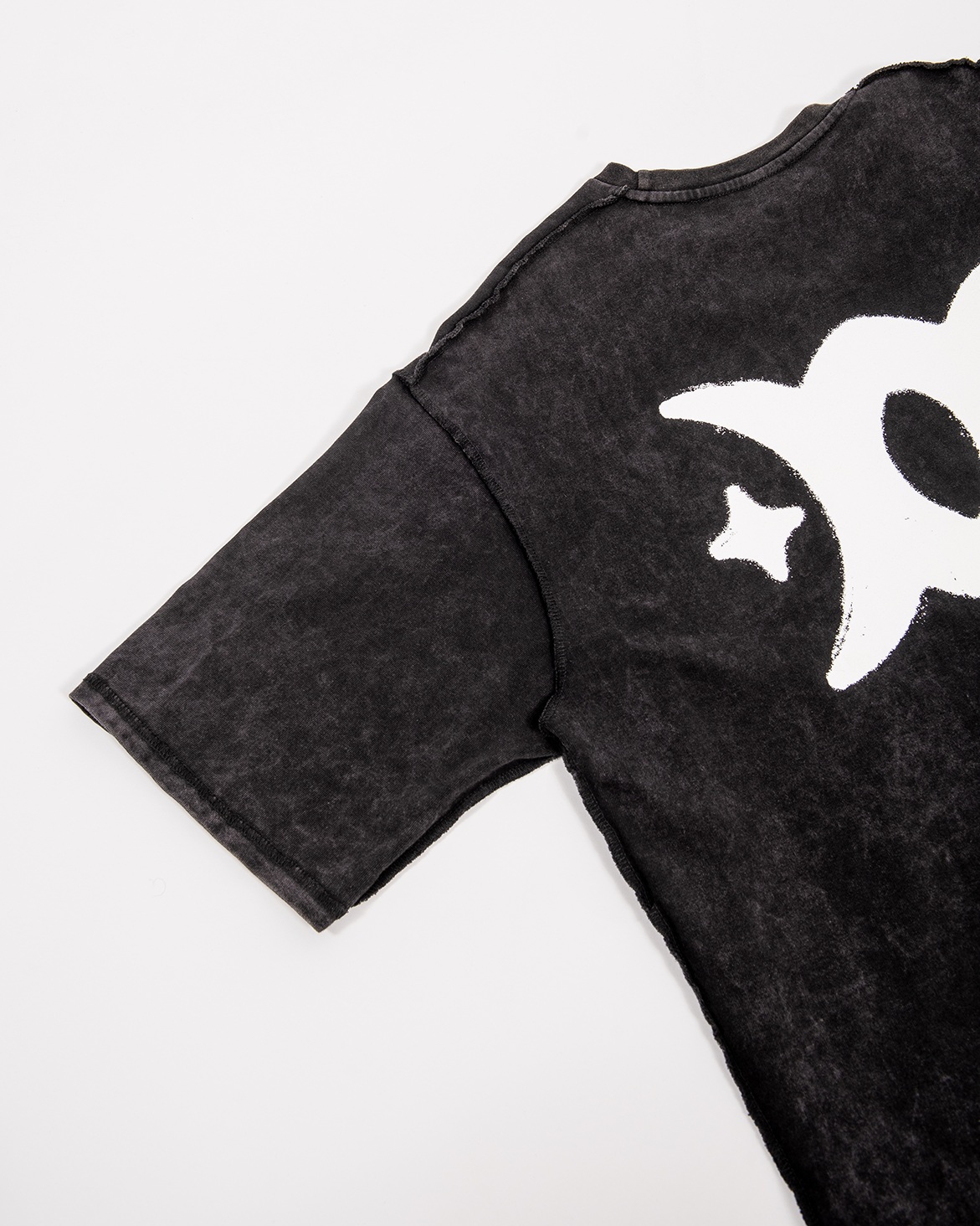 Close-up of a black short sleeve shirt with a white STYXXX logo.