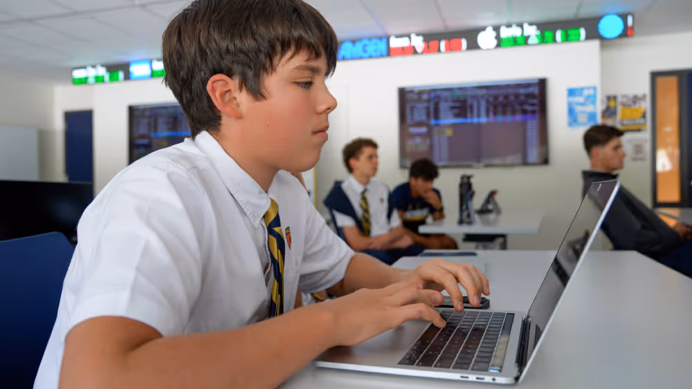 interstock usa student from belen jesuit school looking at a laptop in classroom