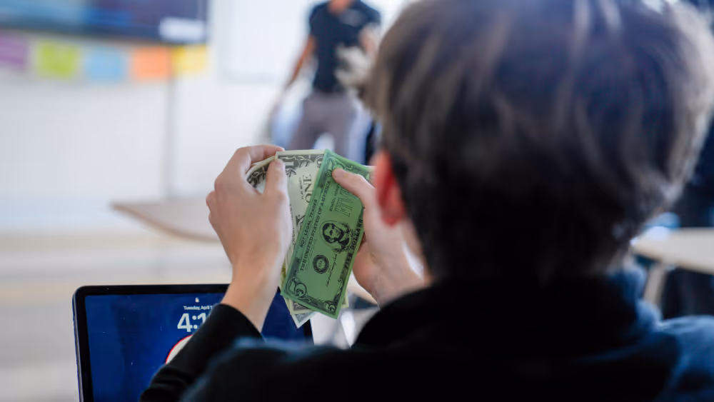 close-up of student counting money for stock trading