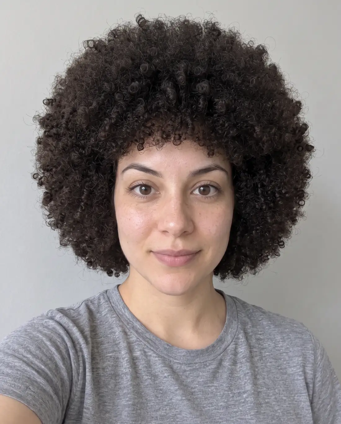 Penteado arredondado com cachos afro densos e definidos