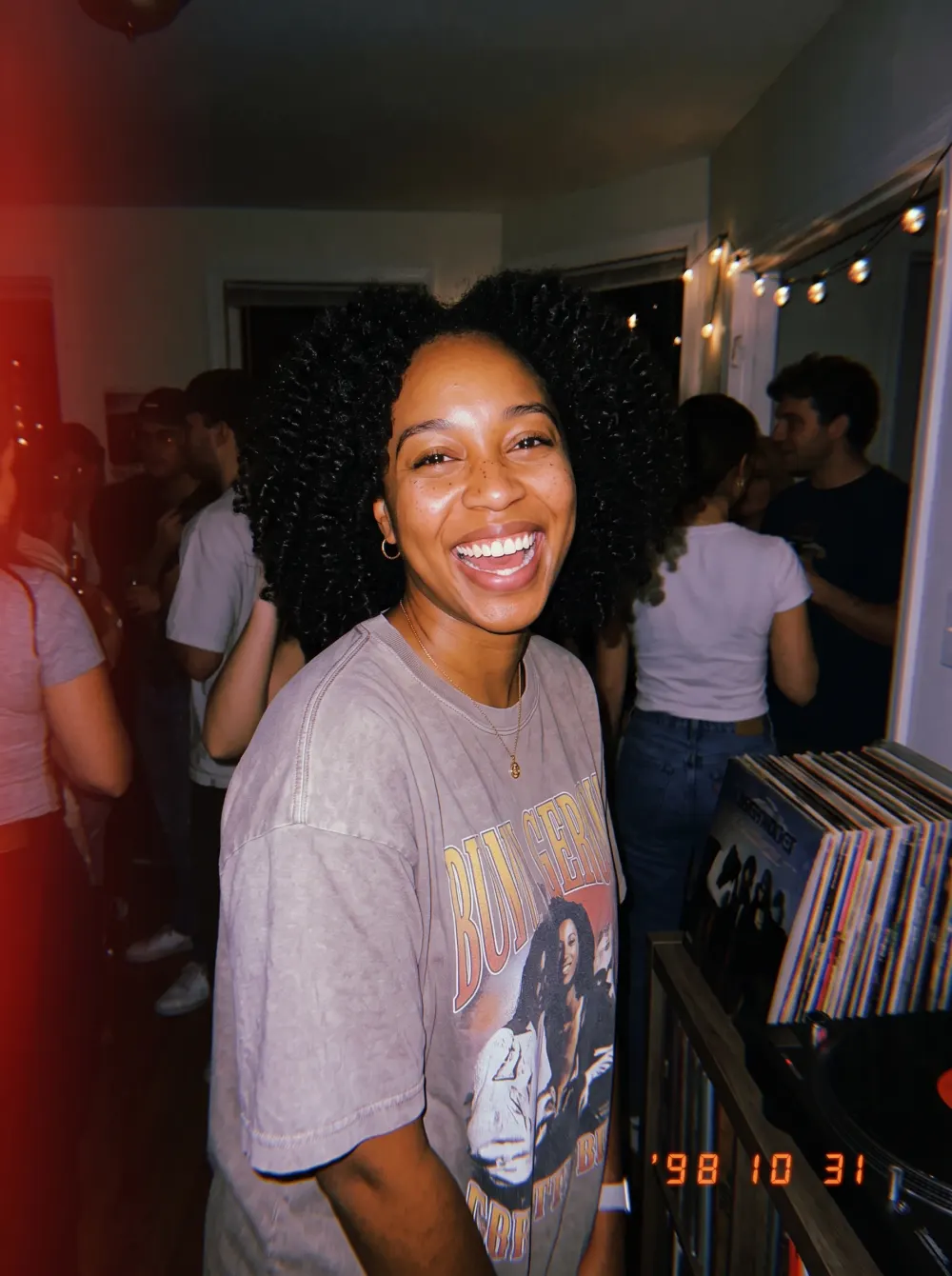 Laughing woman at a 90s house party, flash photo with a '98 10 31 date stamp