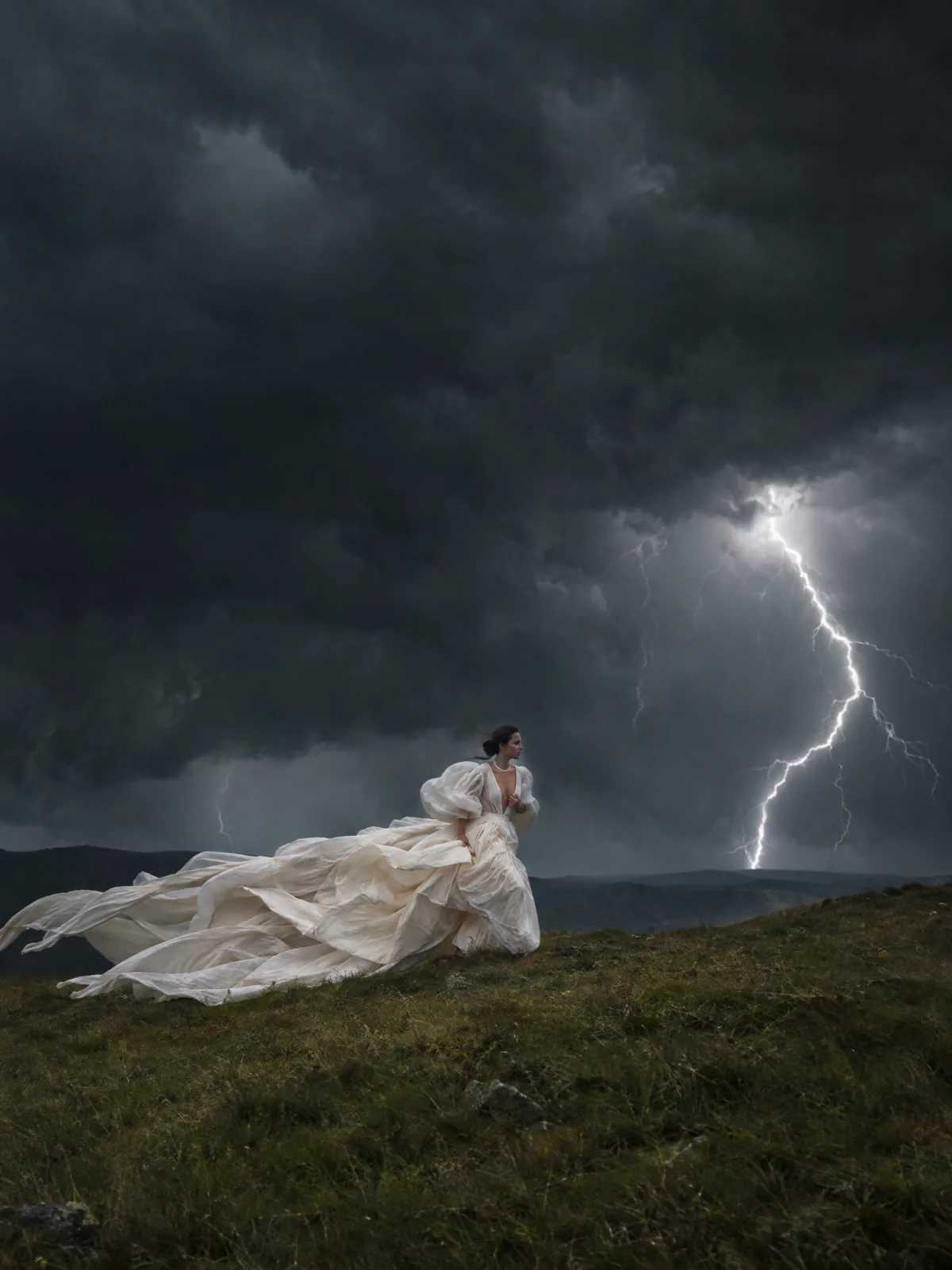 Result of the Storm couture editorial prompt: a woman in an ivory couture gown runs across a grassy hill under black storm clouds, lightning striking behind her