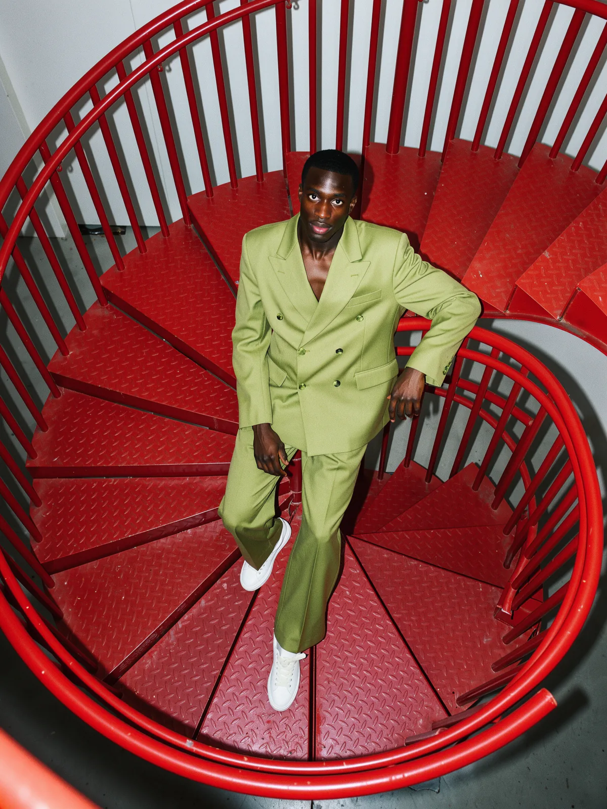 Result of the Pistachio suit on a red spiral stair prompt: man in a pistachio double-breasted suit and white sneakers on a red spiral staircase, shot from above