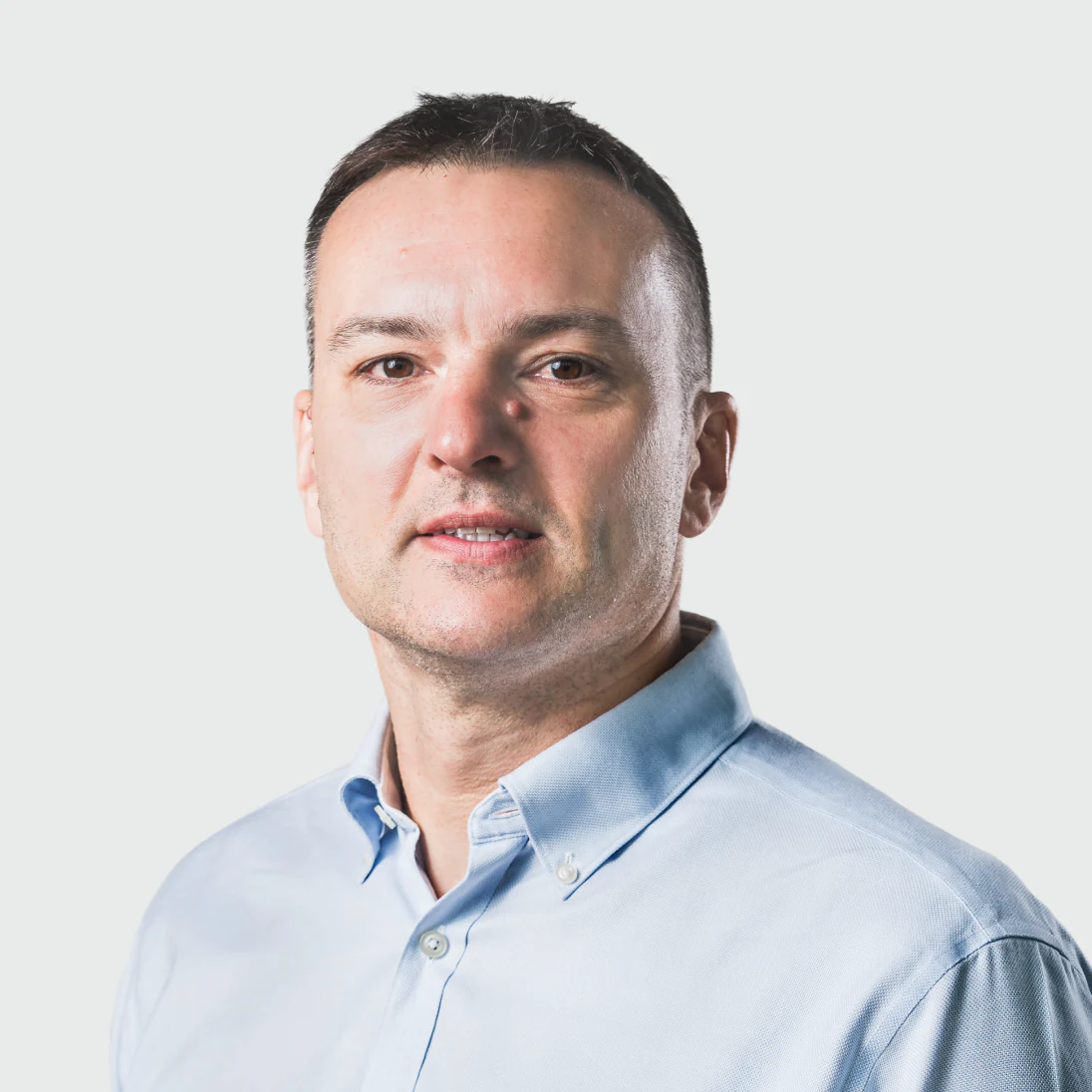 Photo of James Rimmer, Head of Enterprise at Genomics Ltd, in a buttoned shirt, looking slightly off camera.