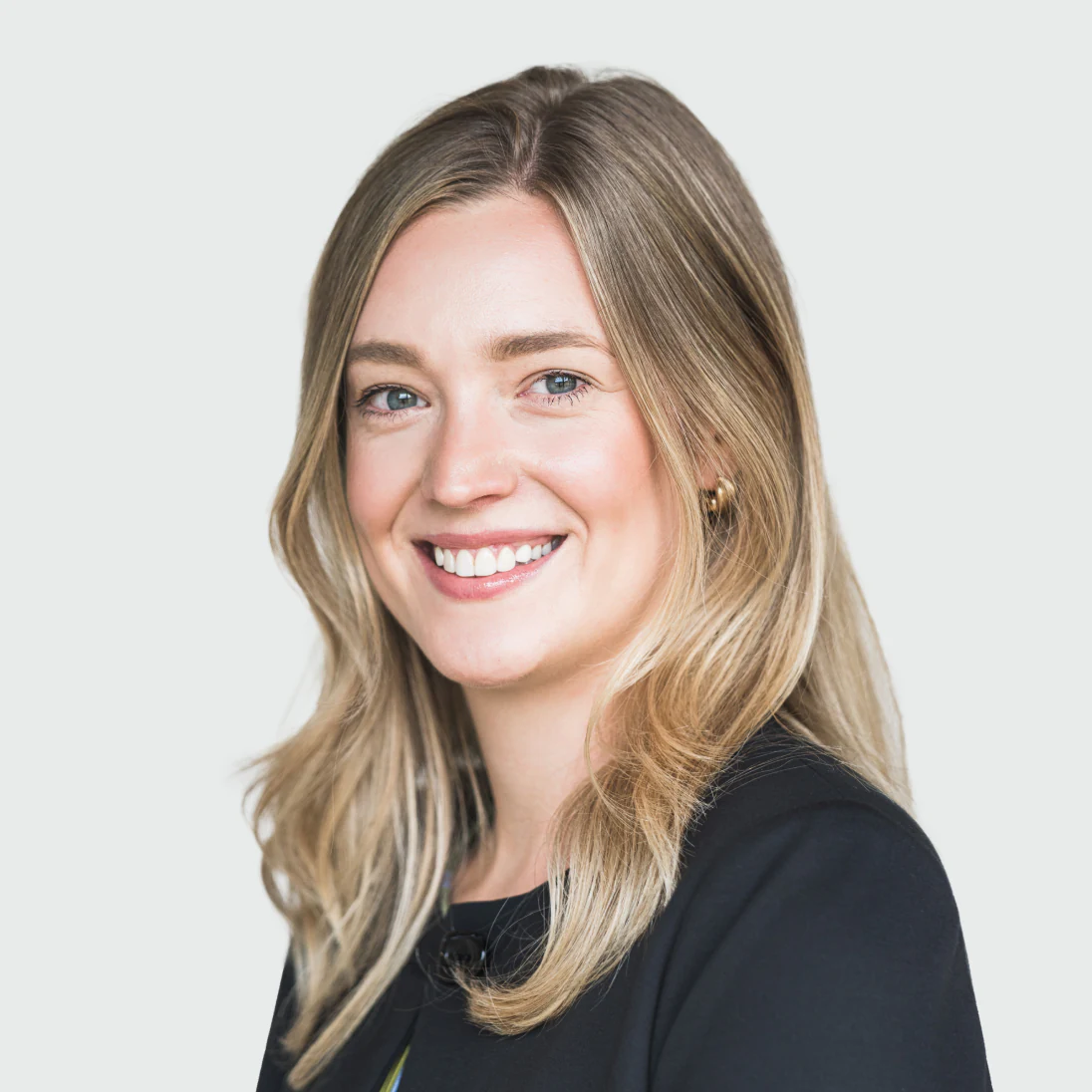Photo of Michaela Broadhurst, Head of Corporate Development at Genomics Ltd, smiling brightly in a black blazer.