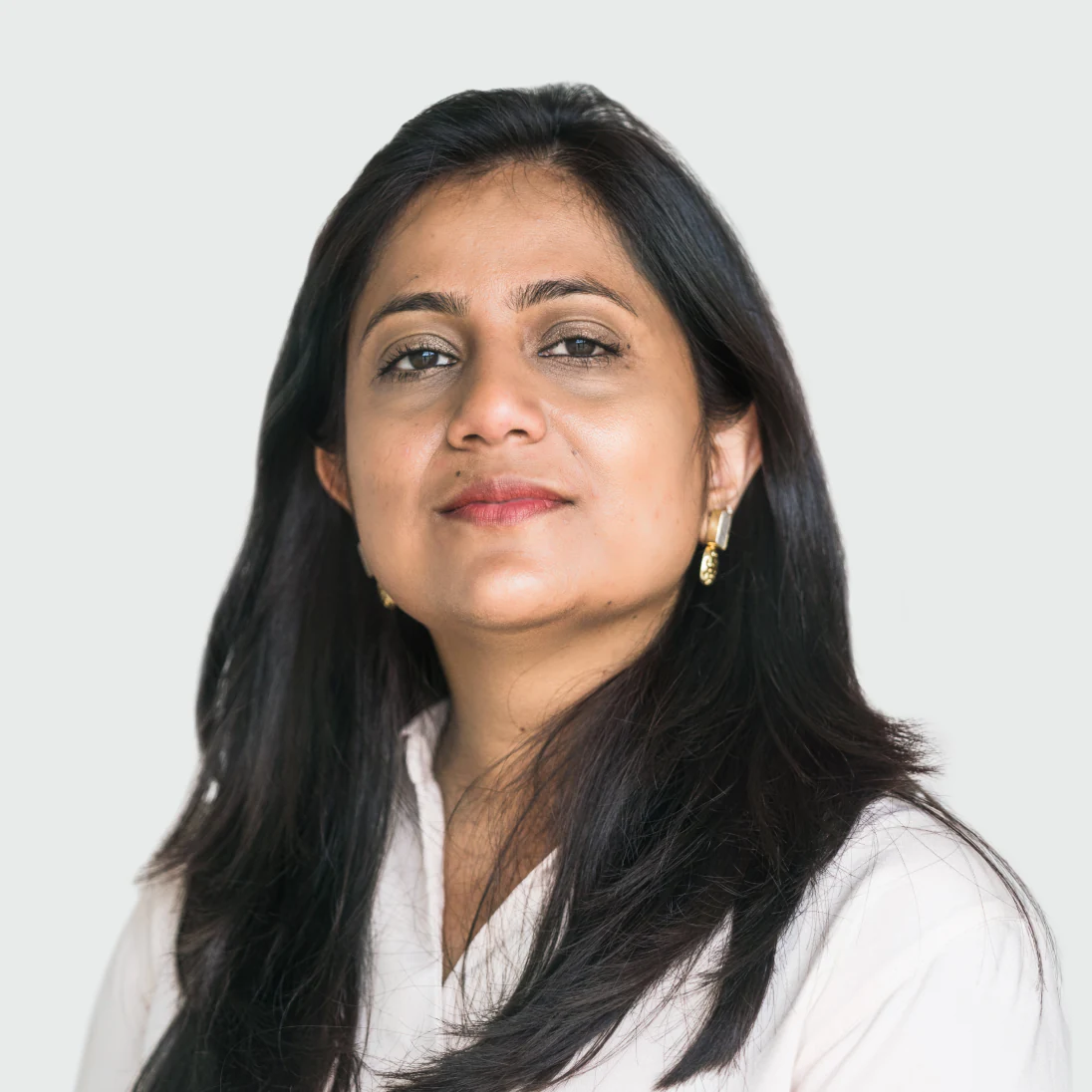 Photo of Sneha Bakshi, Chief People Officer of Genomics Ltd, wearing a light shirt and looking confidently at the camera.