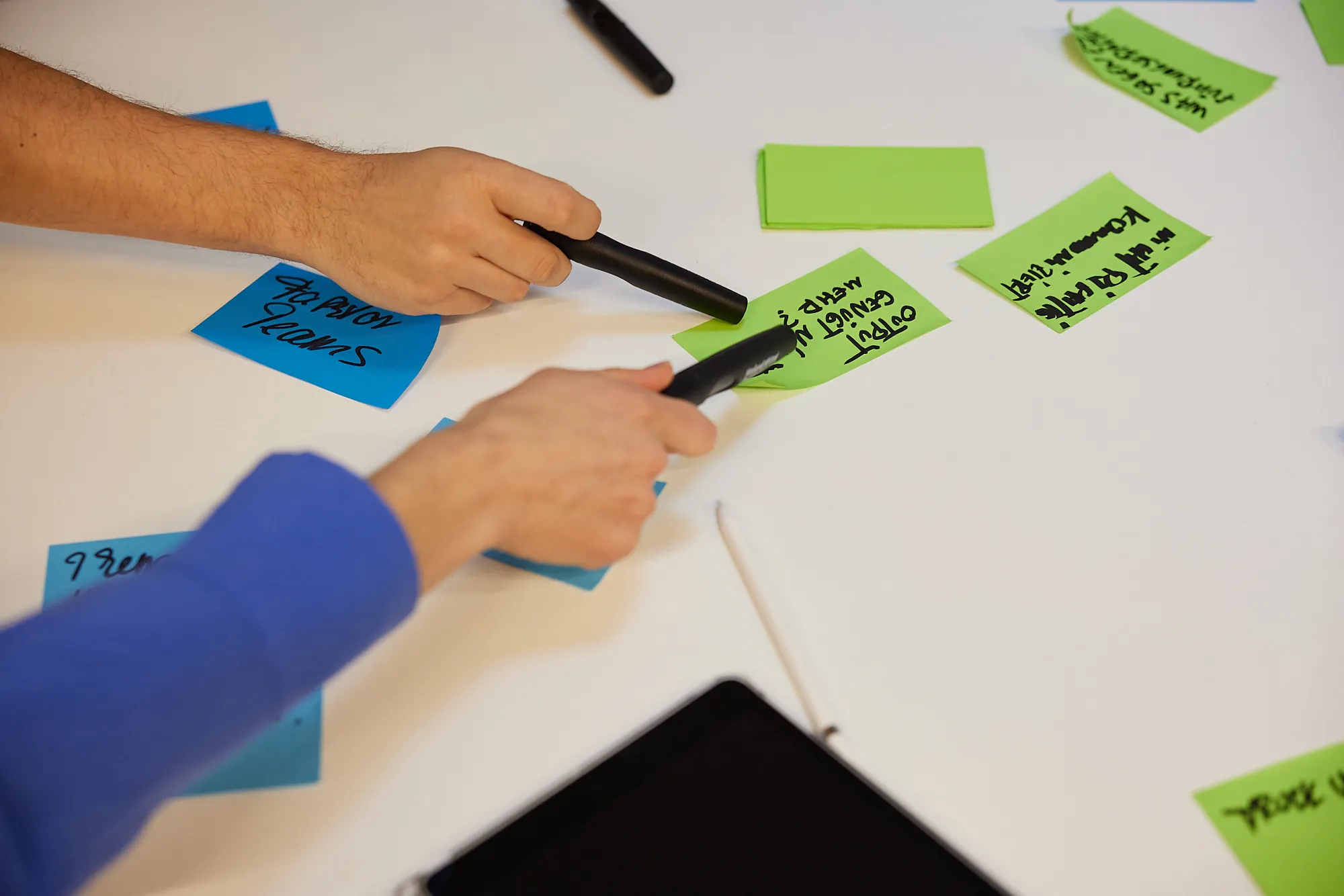 Workshop-Moderation mit Post-it und Stiften