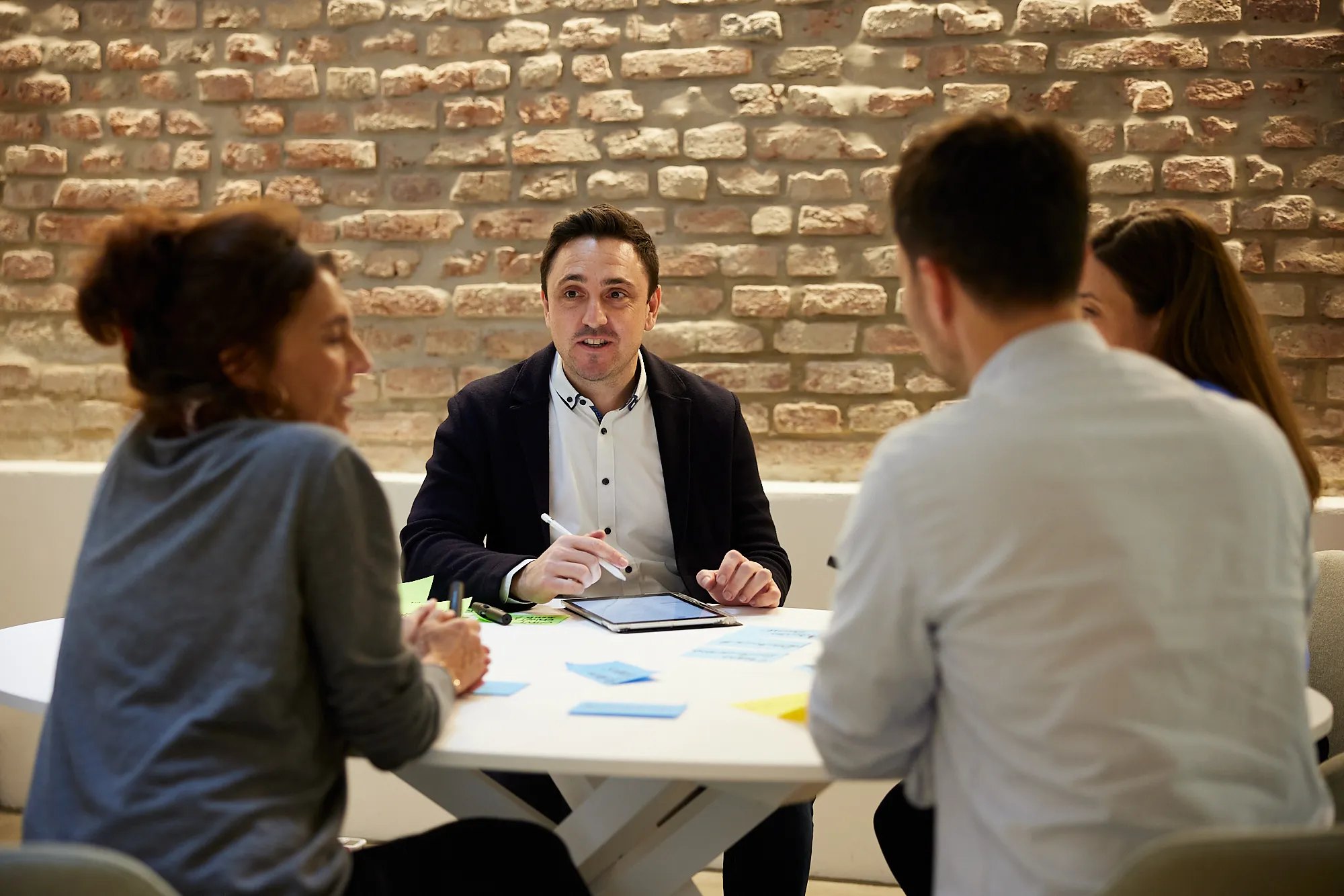 Moderator leitet ein Teamcoaching mit vier Teilnehmenden – Fokus auf Austausch und Zusammenarbeit
