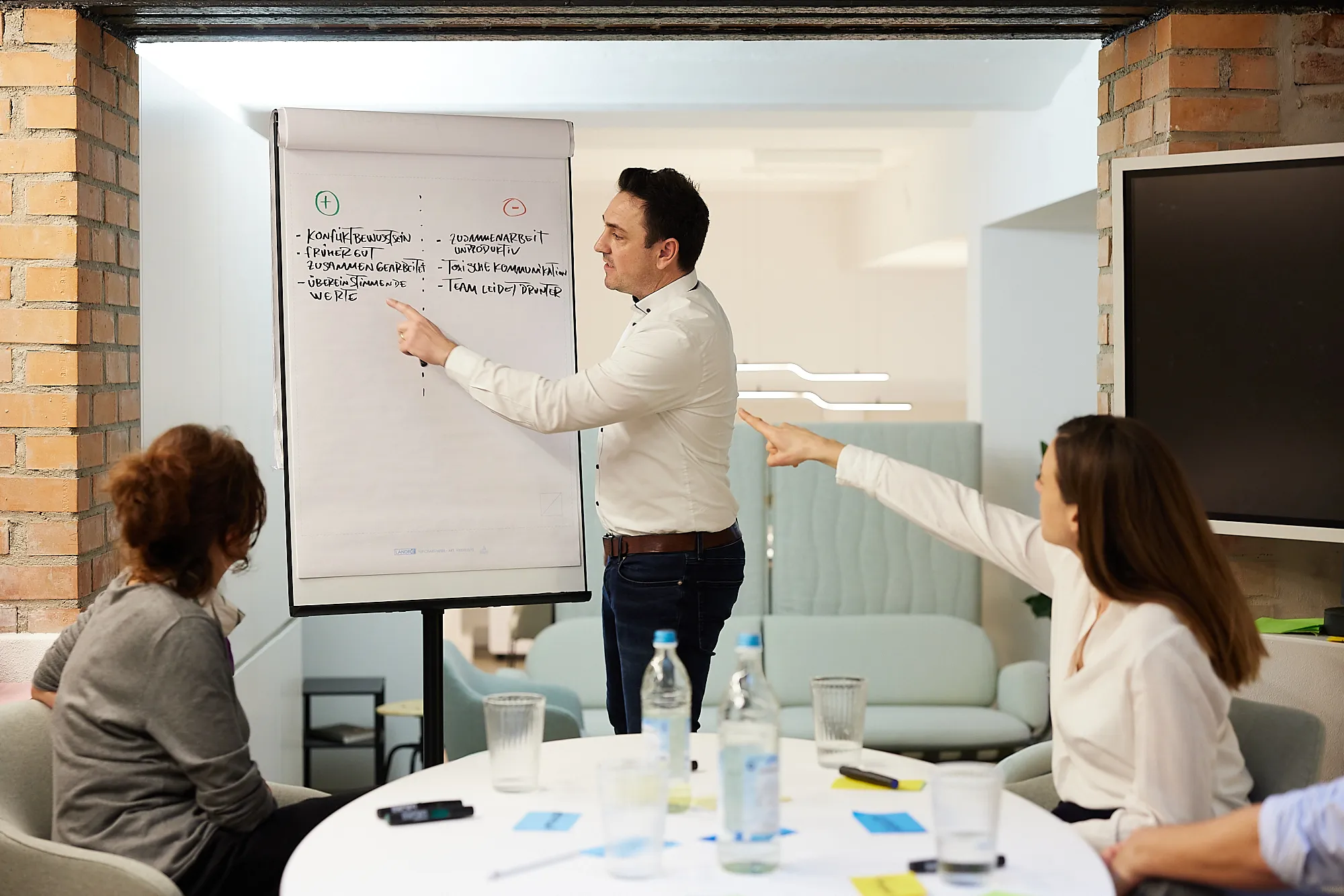 Moderator erklärt Stichpunkte auf Flipchart