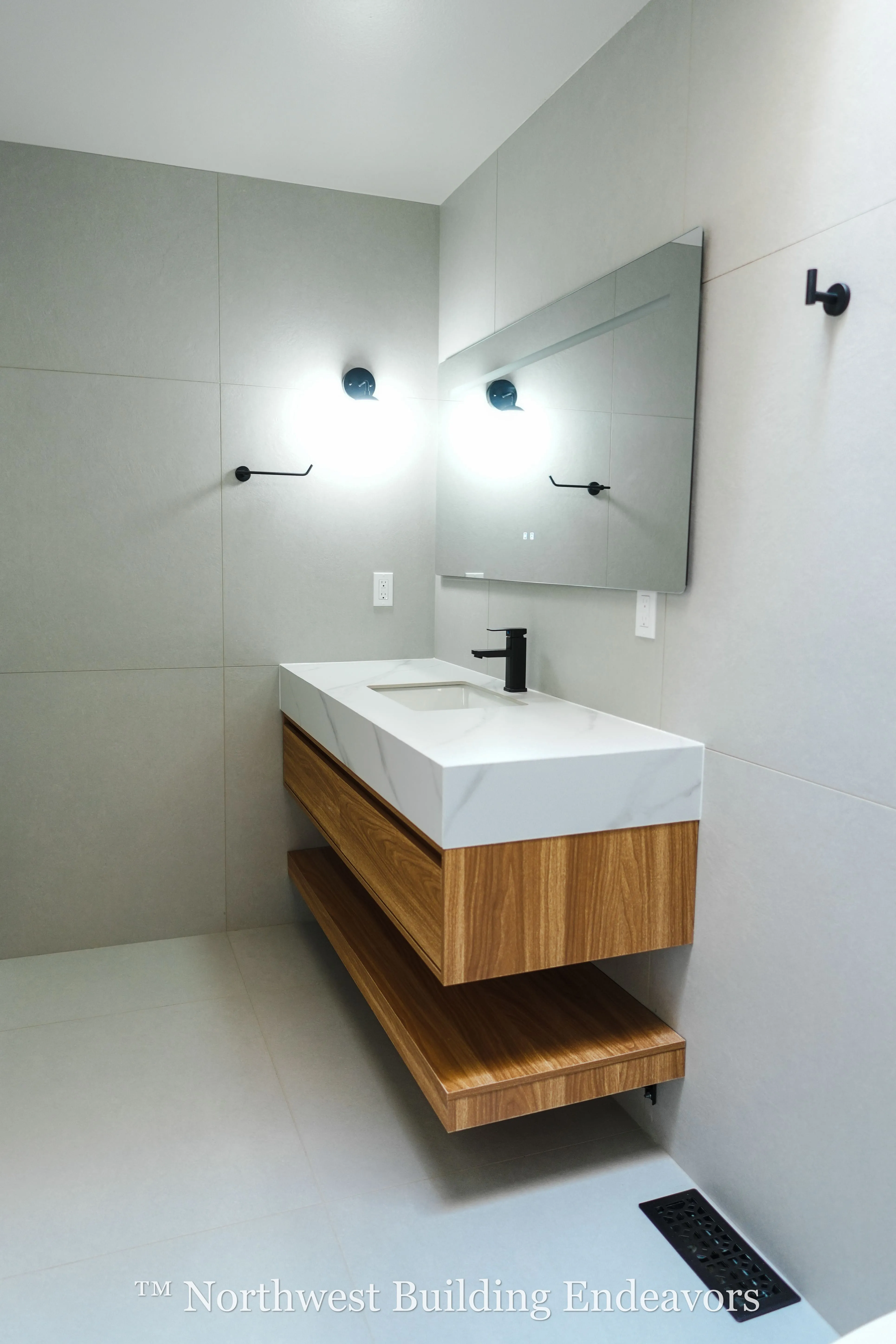 Modern bathroom with floating wooden vanity, white rectangular sink, black faucet, wall-mounted mirror, and two wall lights.