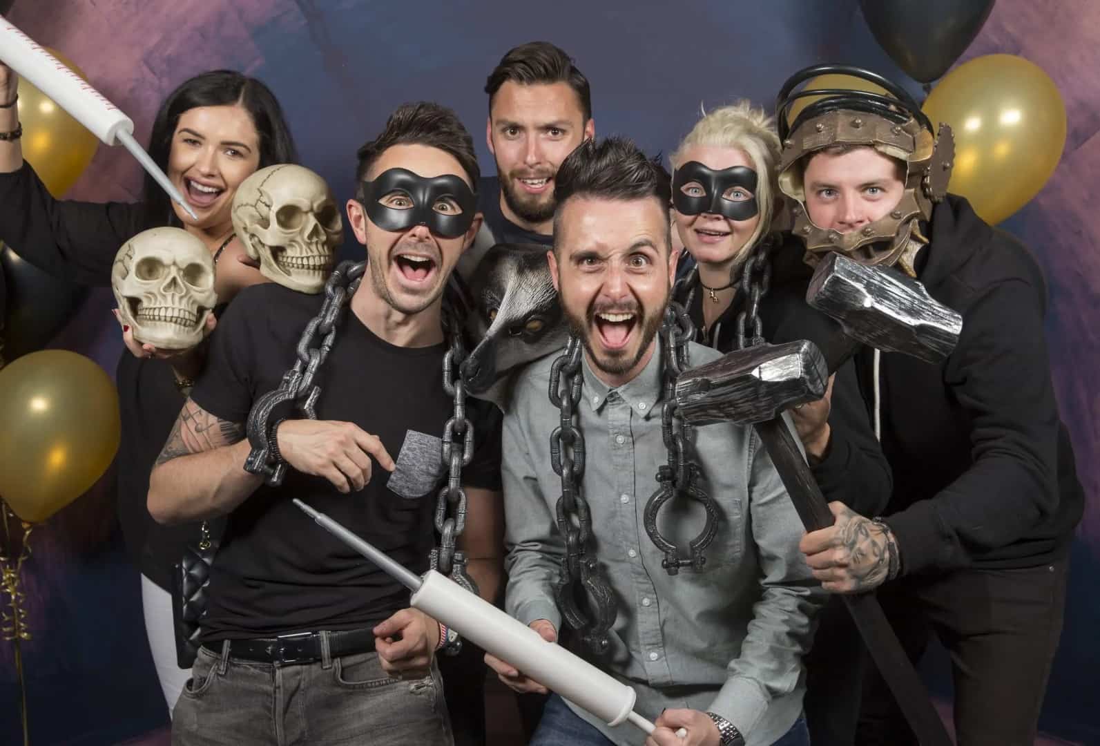 A large group of friends laughing and cheering together before a stag and hen party escape room session.