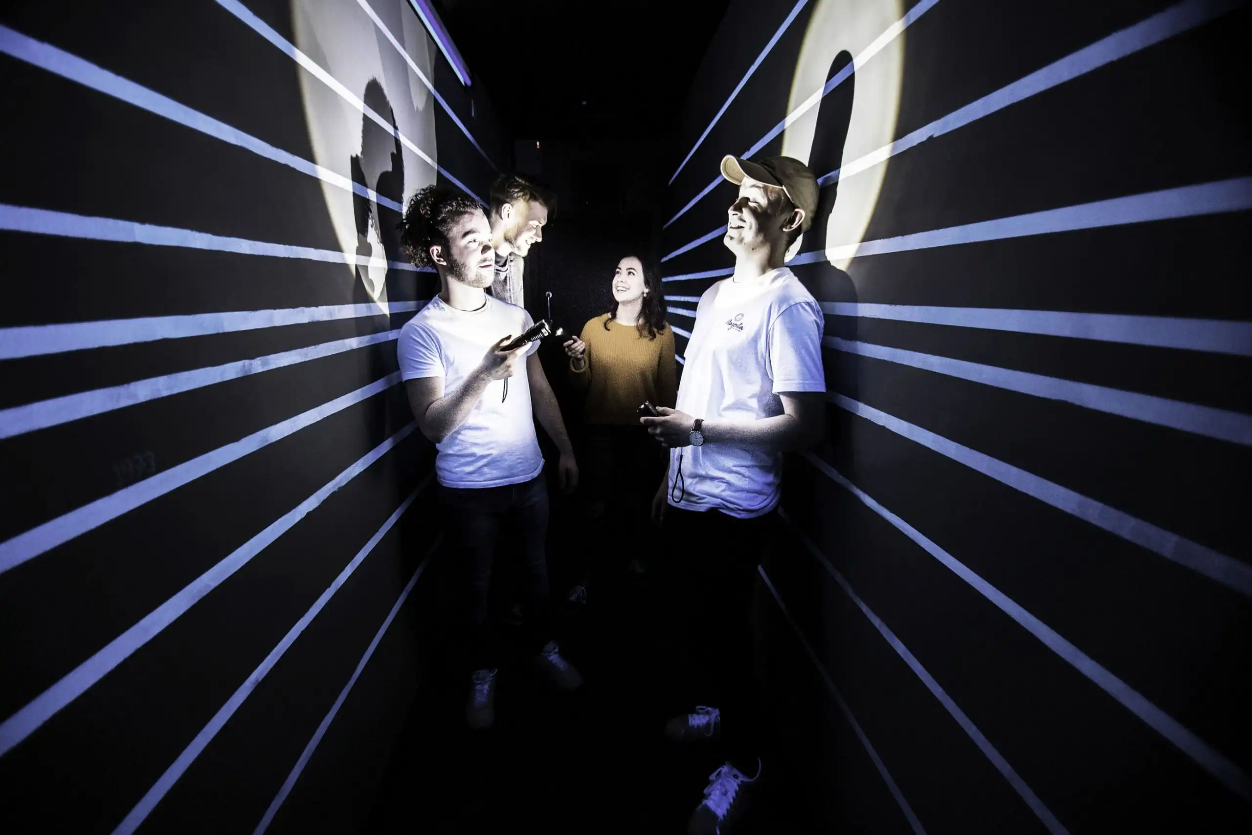 Mixed-age group of players working through clues in a themed escape room.