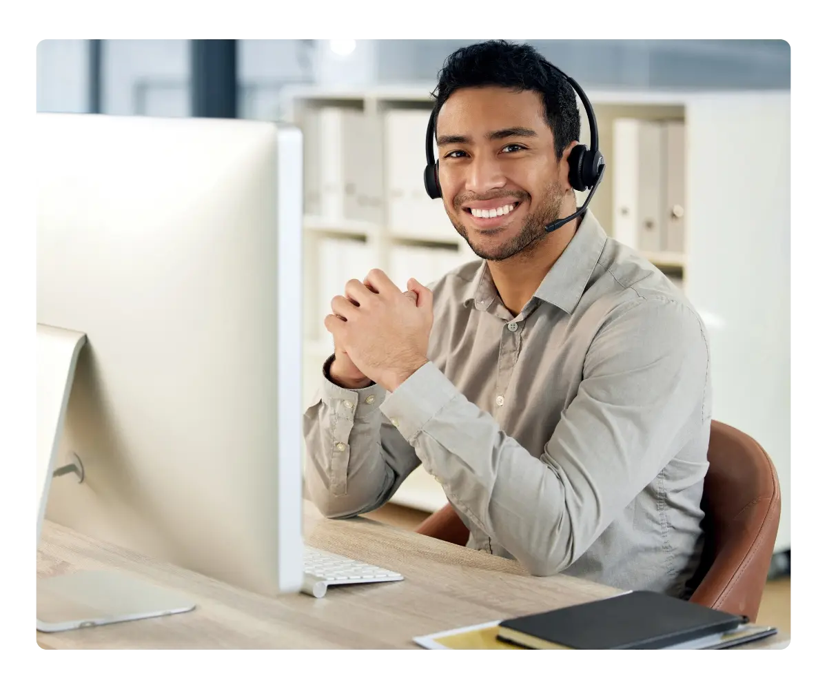 Support professional with headset at a desktop, referring teams to Kommunicate through the affiliate program.