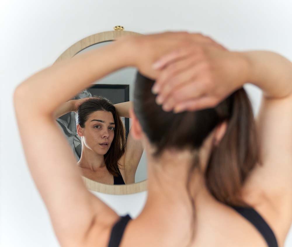 Mujer observando señales en su piel que necesitan tratamiento de recuperación facial