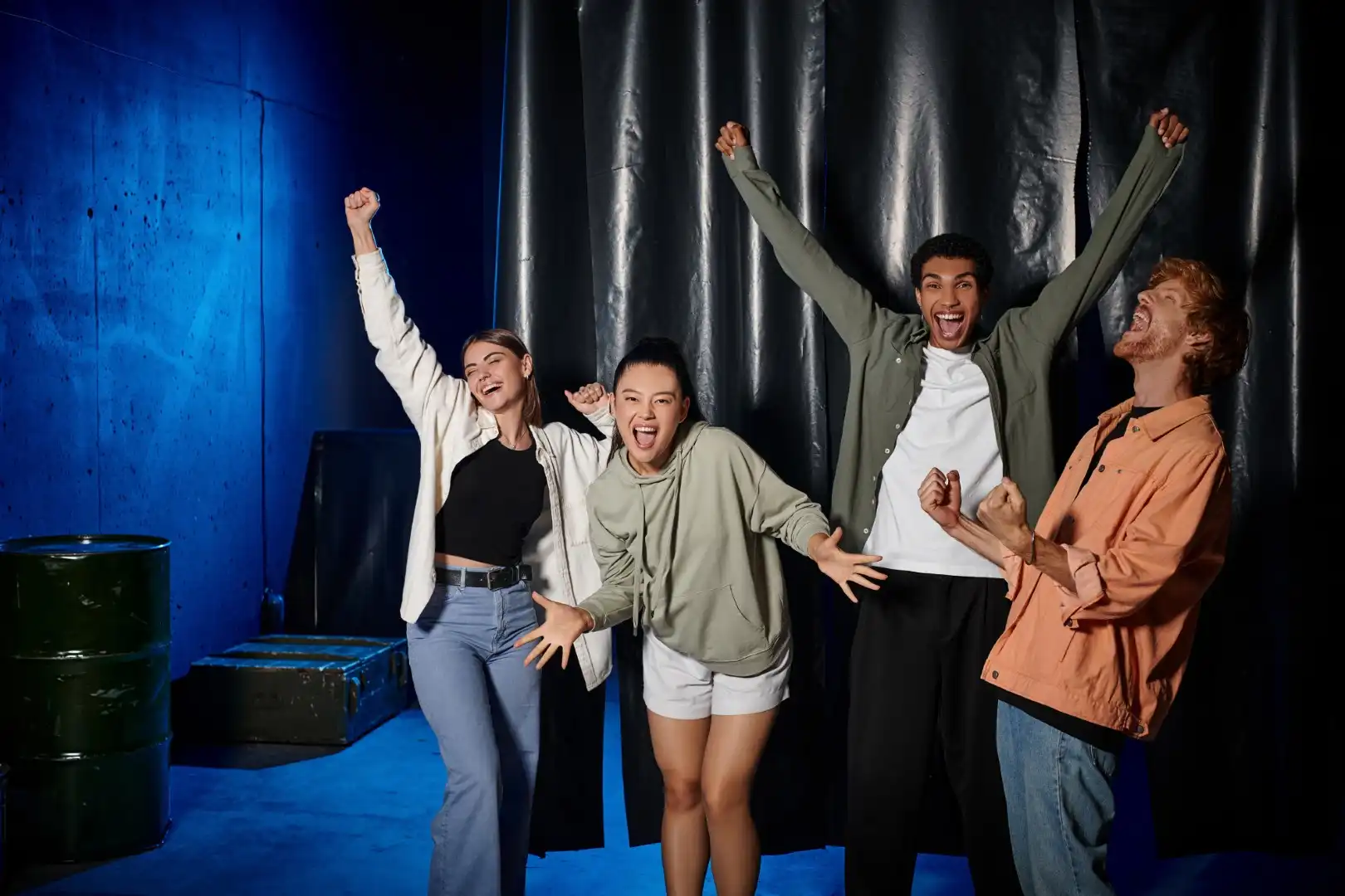 A team of escape room players cheering and celebrating after successfully escaping the room within the time limit