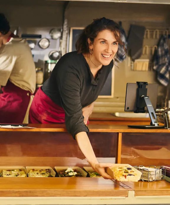 Mujer en un foodtruck sirviendo comida