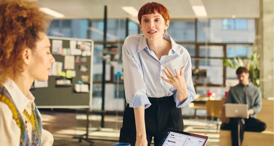 Mujer en su agencia hablando con una compañera