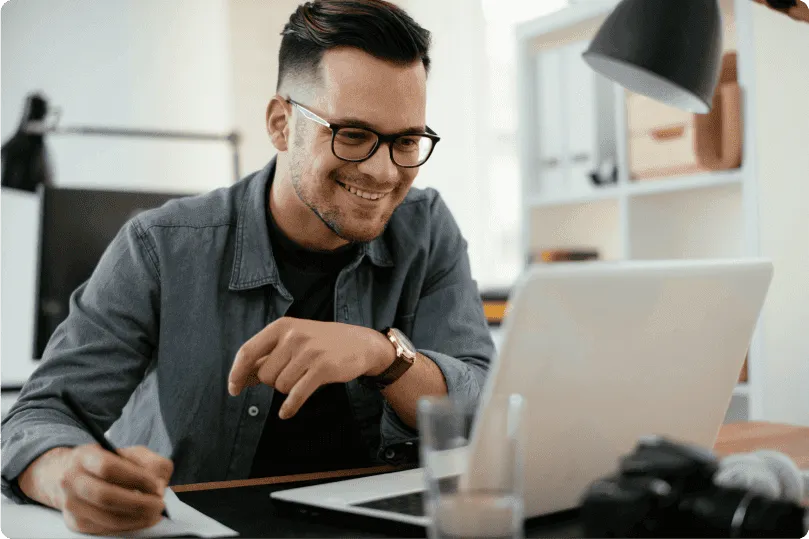 Hombre sonriendo trabajando en ordenador