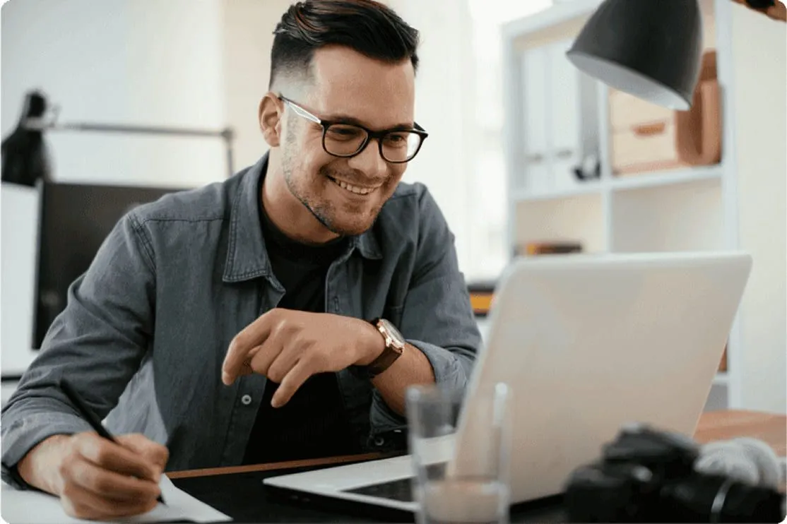 Hombre sonriente trabajando en su ordenador