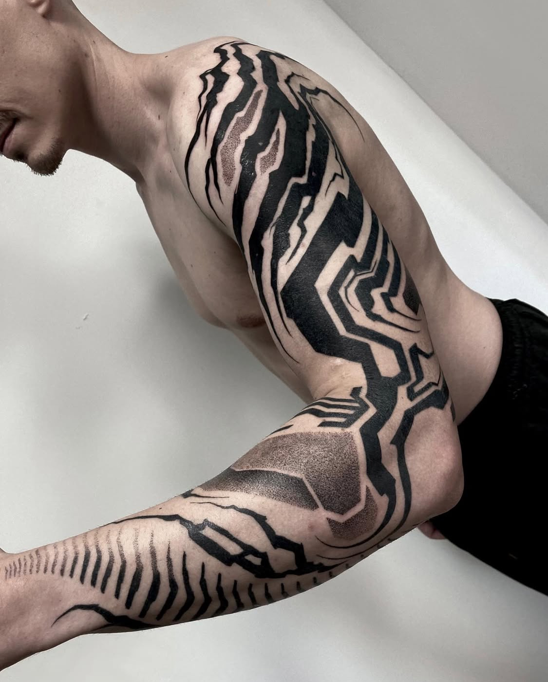 Minimalistisches Tattoo mit blauer Tinte entlang der Rippen.