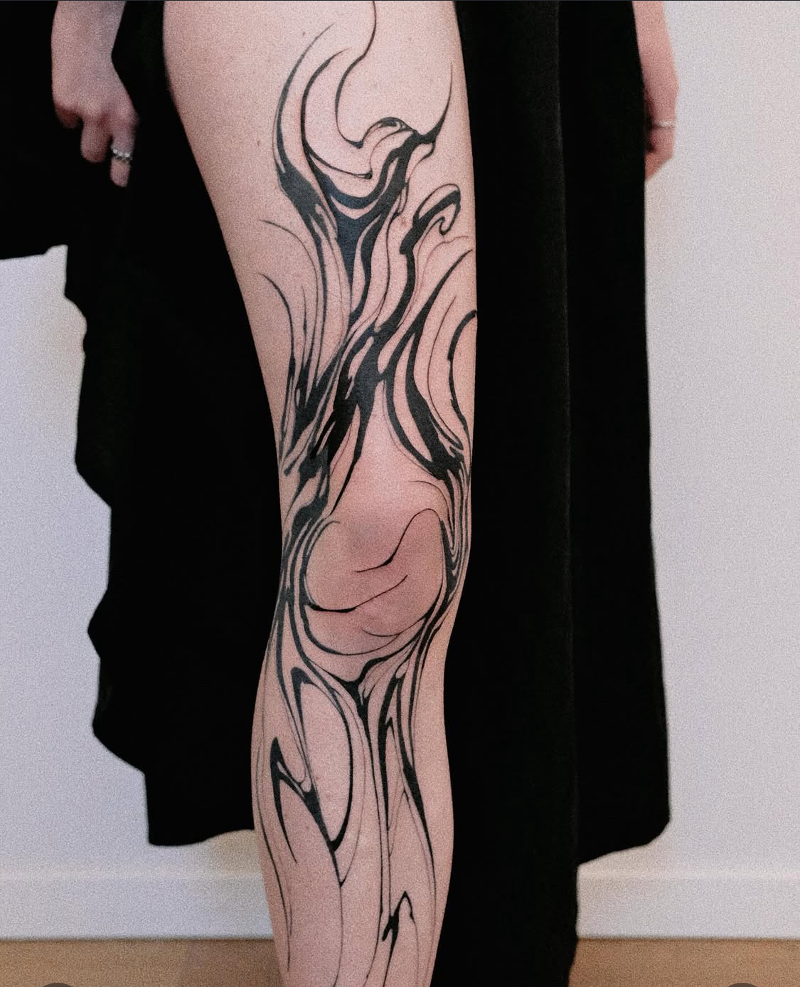 Minimalistisches Tattoo mit blauer Tinte entlang der Rippen.