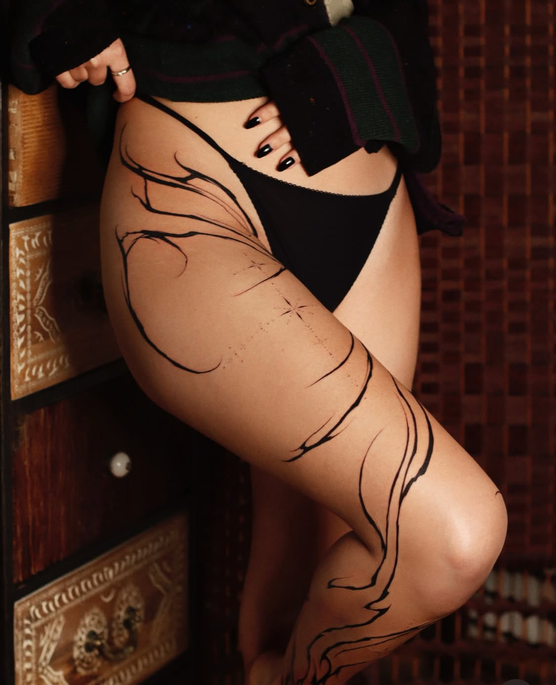 Abstraktes Wirbelsäulen-Tattoo, das den Rücken hinunterfließt, bei Transparent Plattform in Berlin.