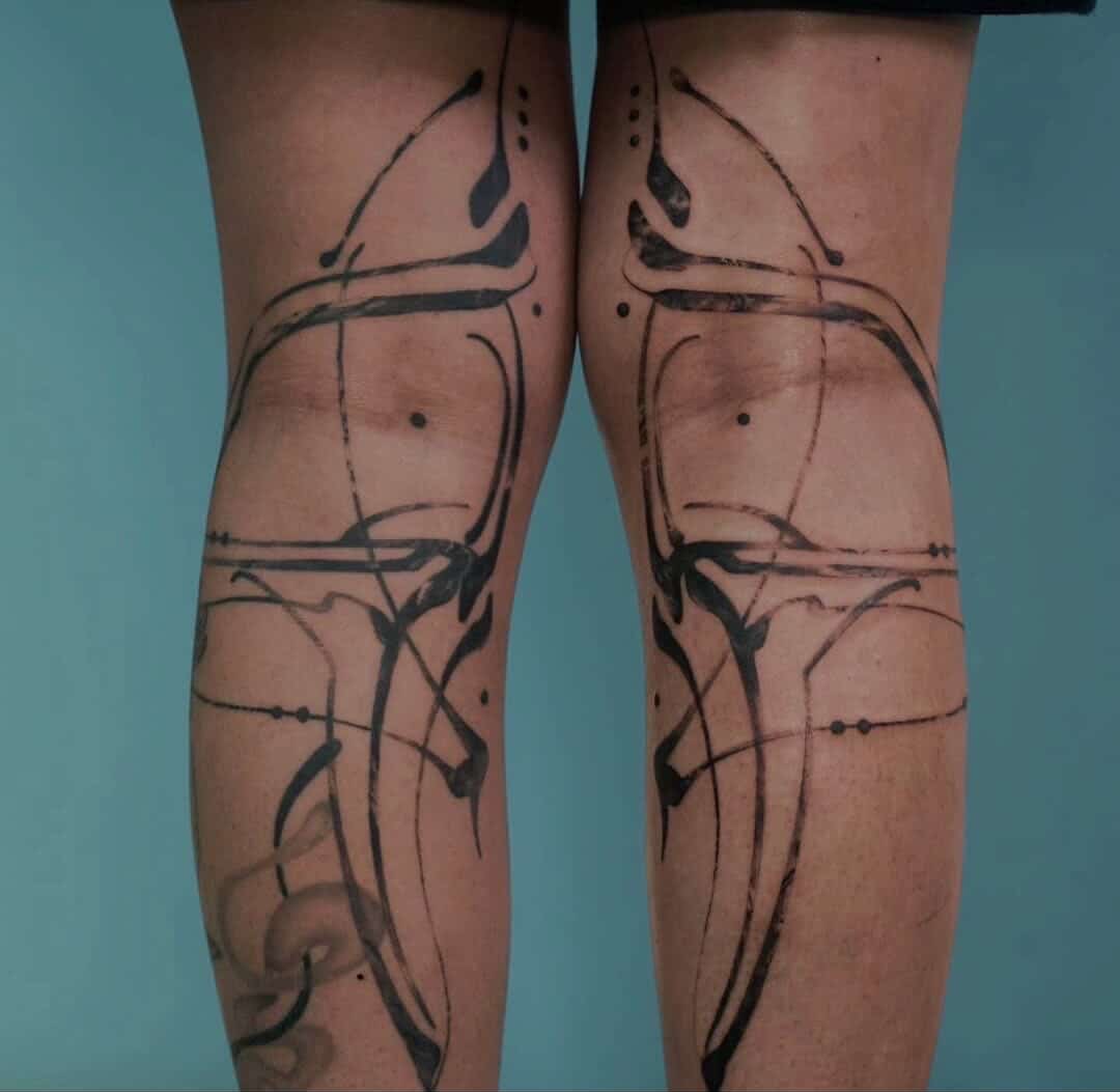 Minimalistisches Tattoo mit blauer Tinte entlang der Rippen.