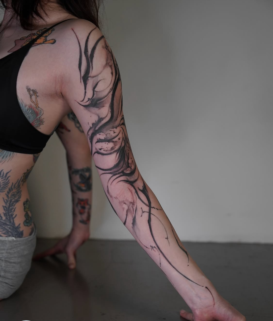 Minimalistisches Tattoo mit blauer Tinte entlang der Rippen.