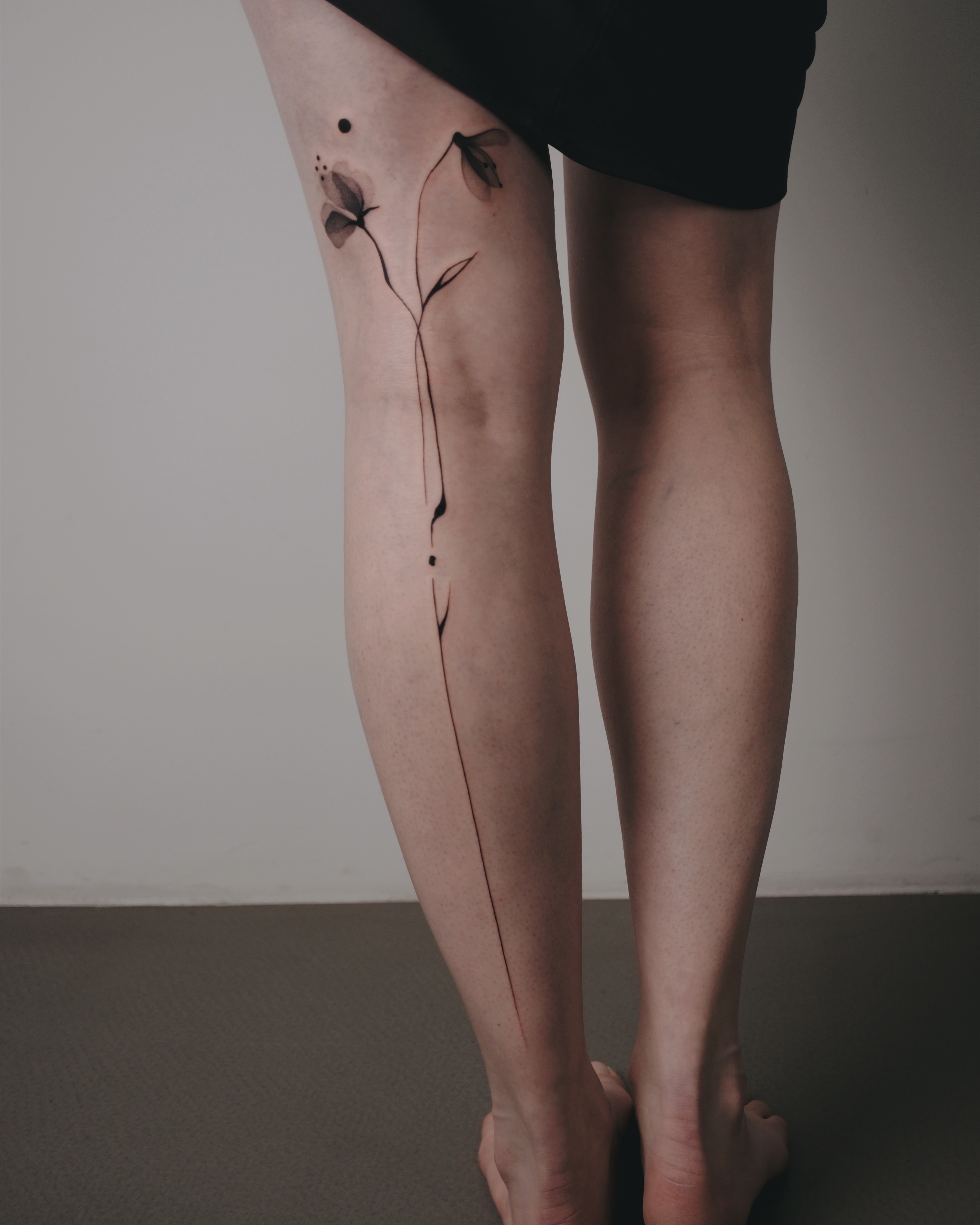 Abstraktes Wirbelsäulen-Tattoo, das den Rücken hinunterfließt, bei Transparent Plattform in Berlin.