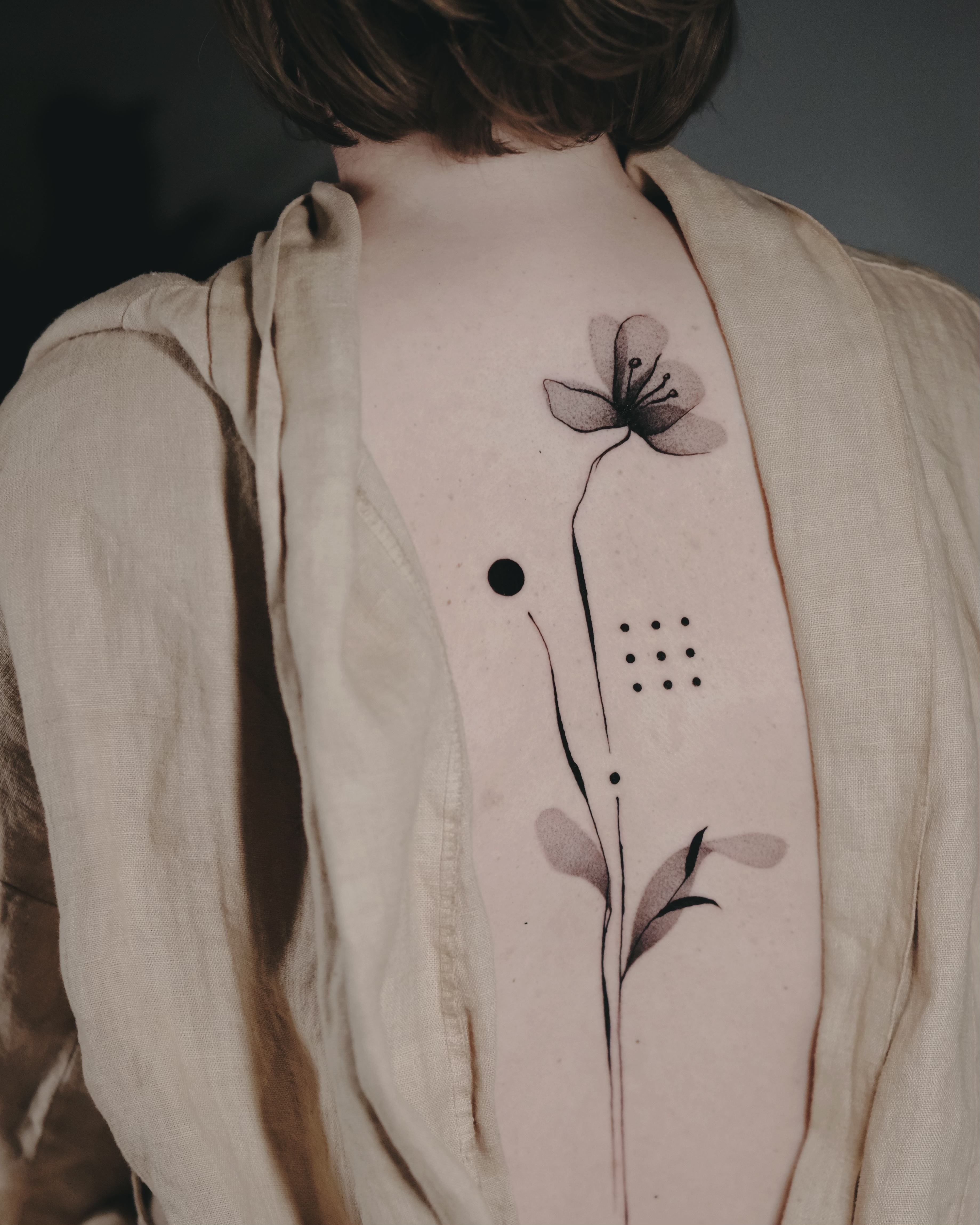 Minimalistisches Tattoo mit blauer Tinte entlang der Rippen.