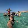 Sophi taking a selfie in the sea with the group behind her