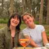 Naoise and a friend at a table in a palm grove