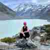 Gillian sitting on rocks beside a glacial lake
