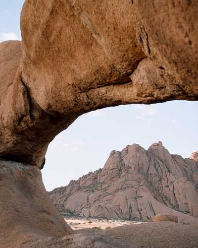 Rock arch framing the granite peaks of Spitzkoppe, Namibia