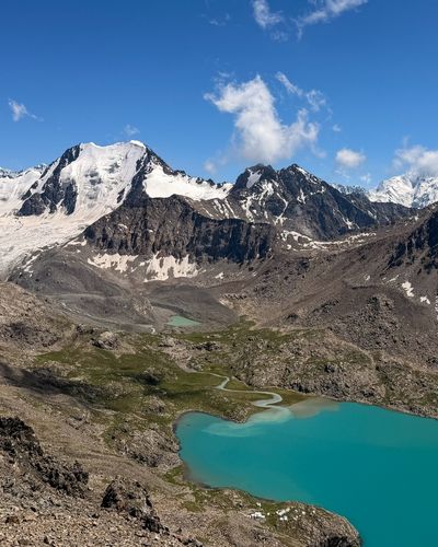 Turquoise Ala Kul Lake below snowy peaks, Kyrgyzstan