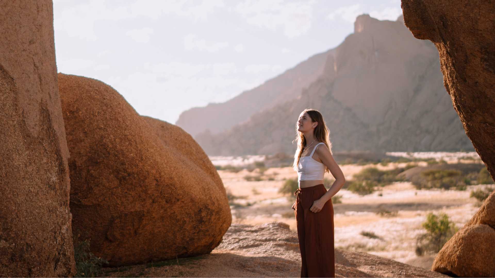 Woman standing among granite boulders in Namibia