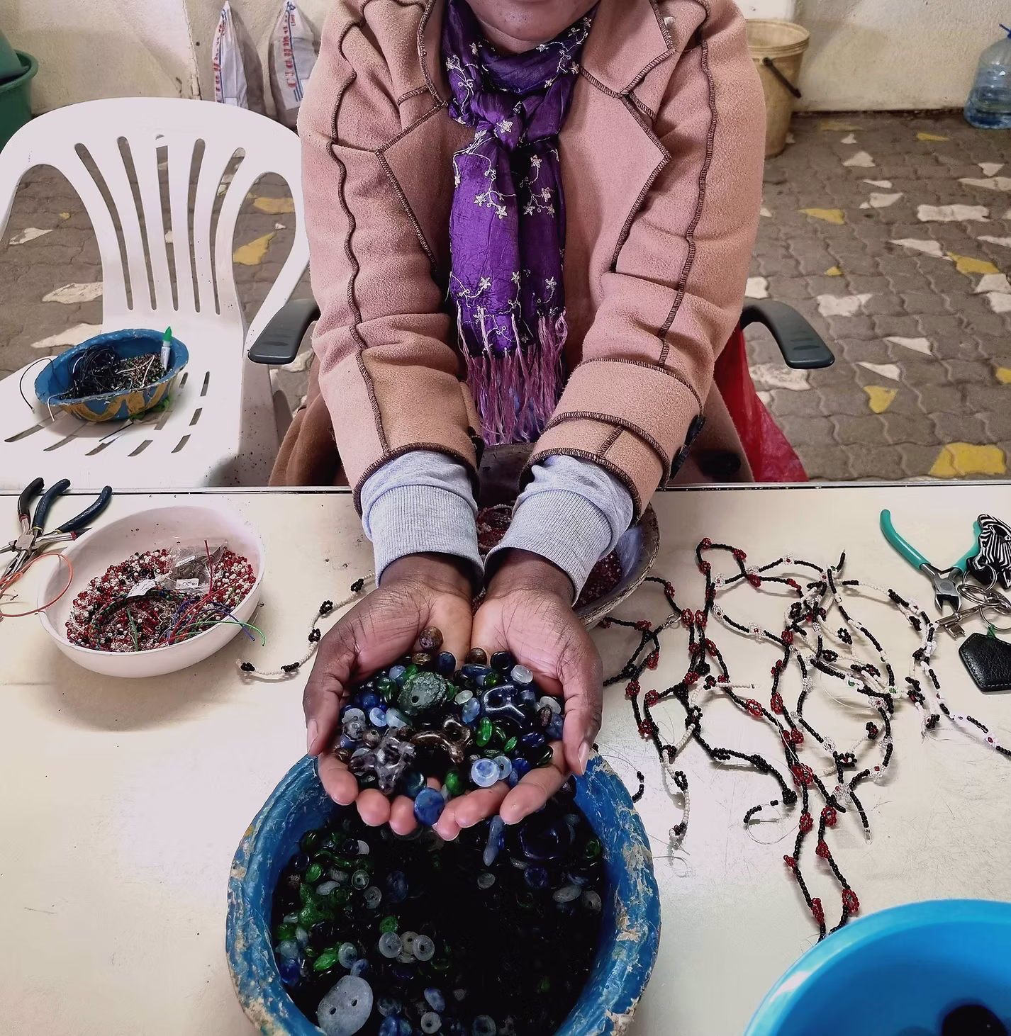 Hands holding beads at a women's jewellery-making class in Namibia