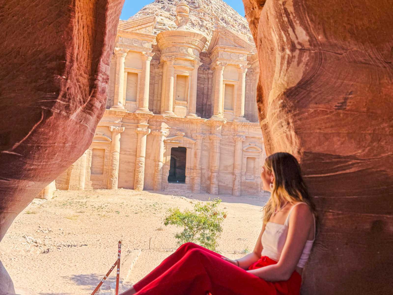 Woman sitting looking out at the Monastery in Petra, Jordan