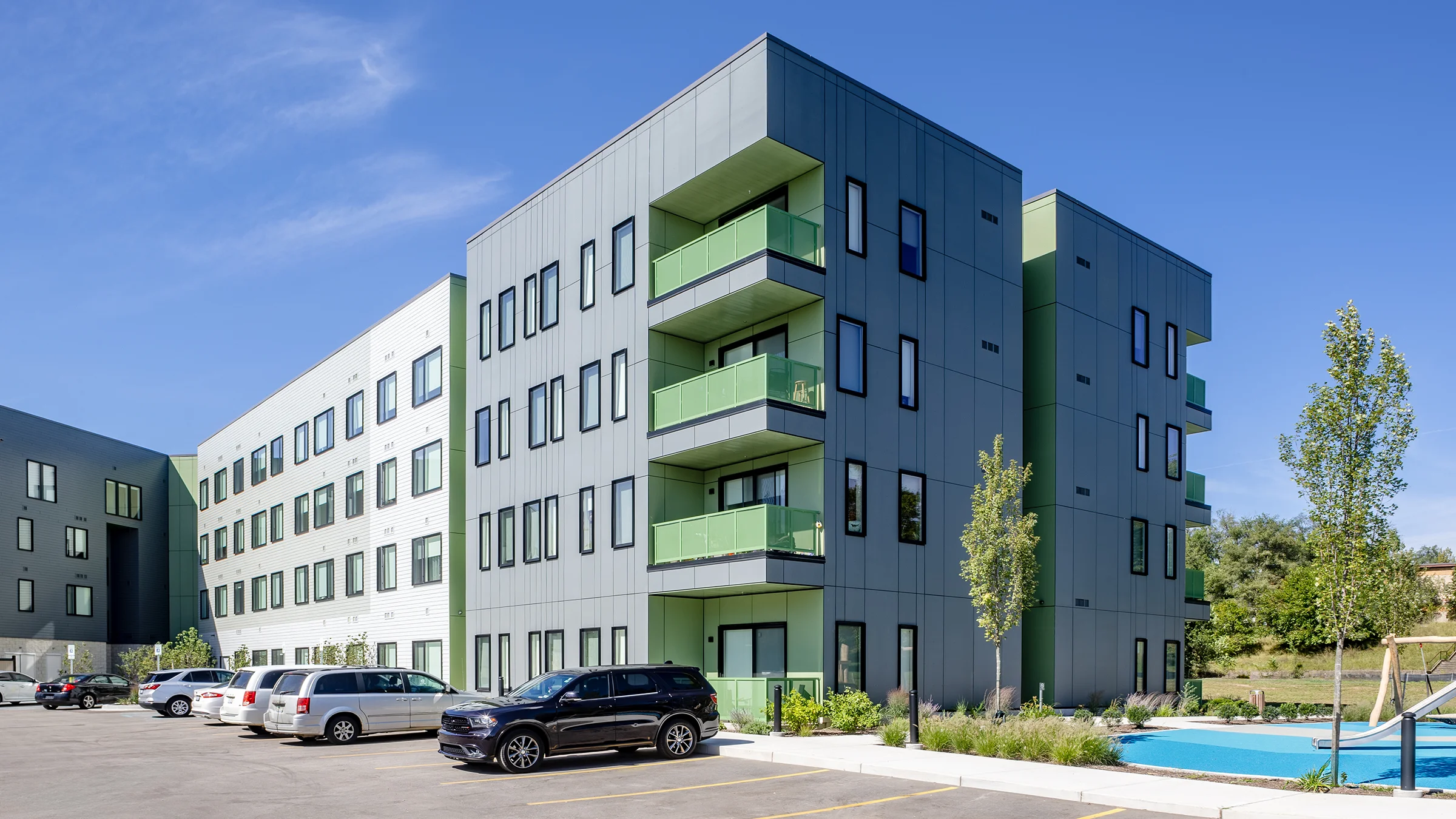Kabo Flats apartment building. Gray with green balconies.