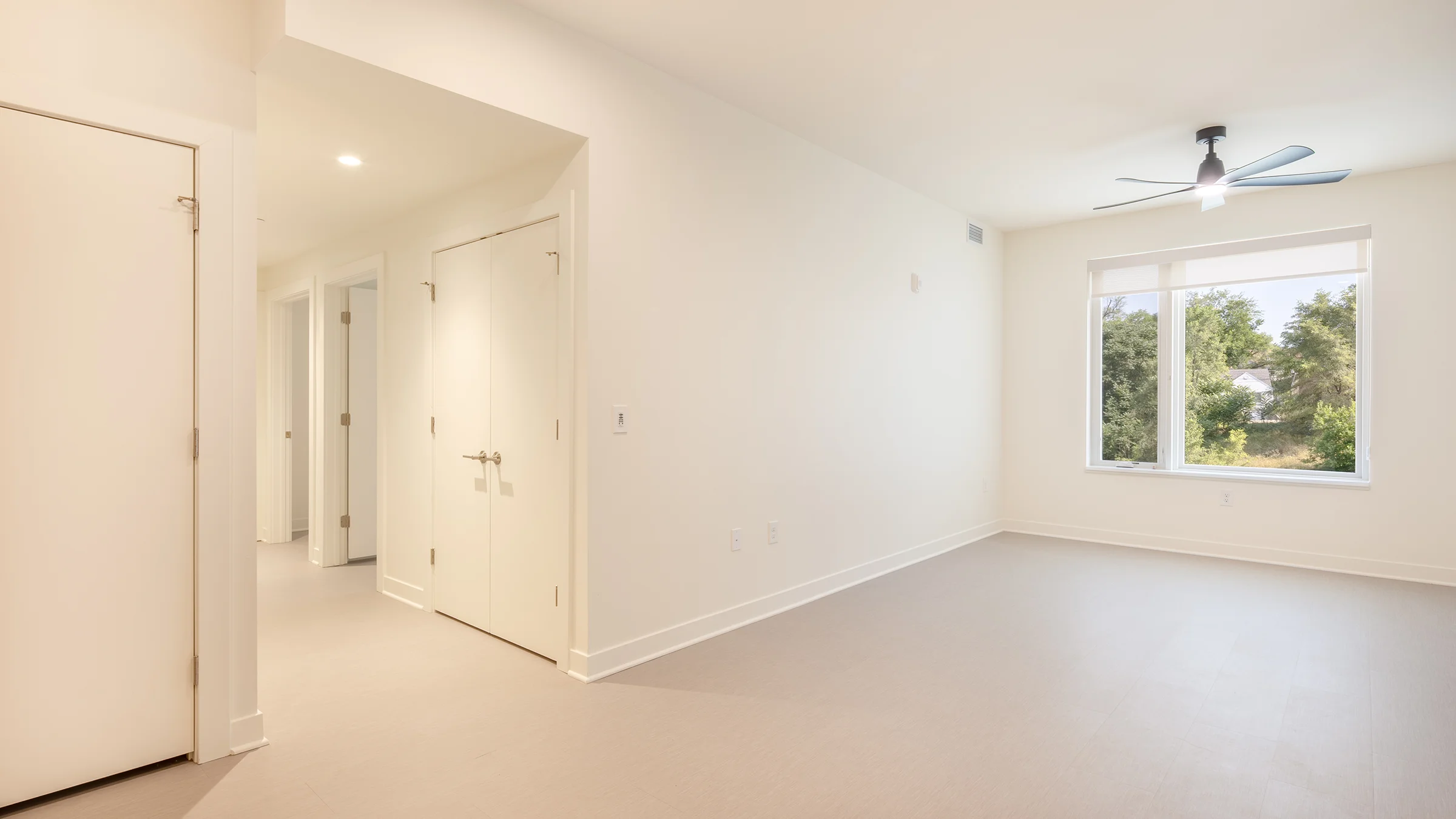 Apartment living room and hallway with white walls and light floors.